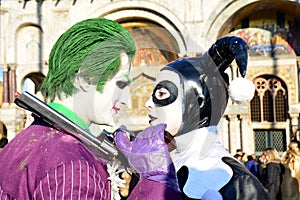 An unidentified man and woman couple wears joker fancy dresses during Venice Carnival